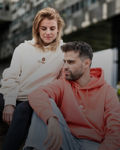 Une femme et un homme sont assis qui portent des hoodies colorés